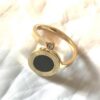 Bague dorée ouverte fine cercle chiffres romains autour fond noir